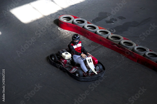 Riding on karting on the auto track. The young guy drives karting.
