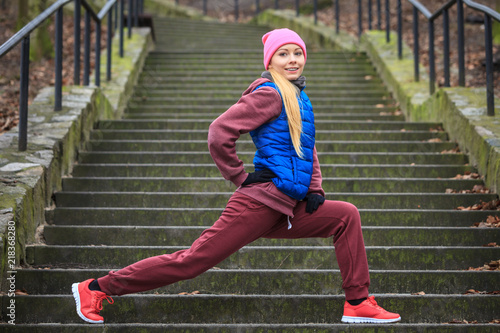 Woman wearing sportswear exercising outside during autumn