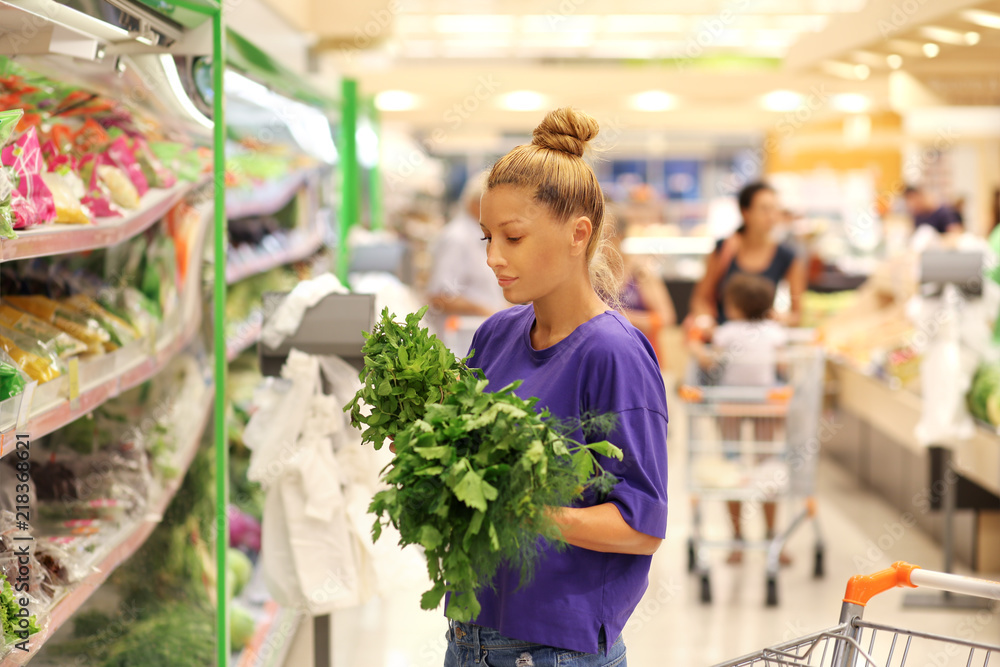 Woman smelling lettuce in the supermarket