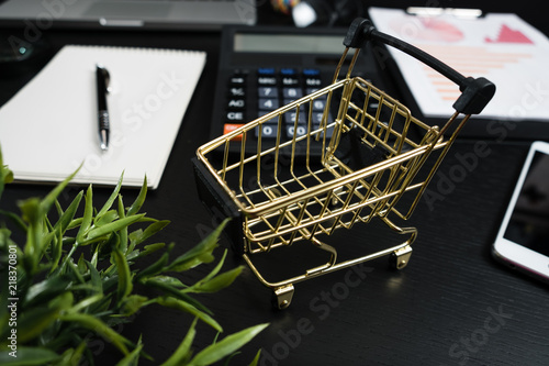 Foto Gold cart, cash and gadgets on a black table.
