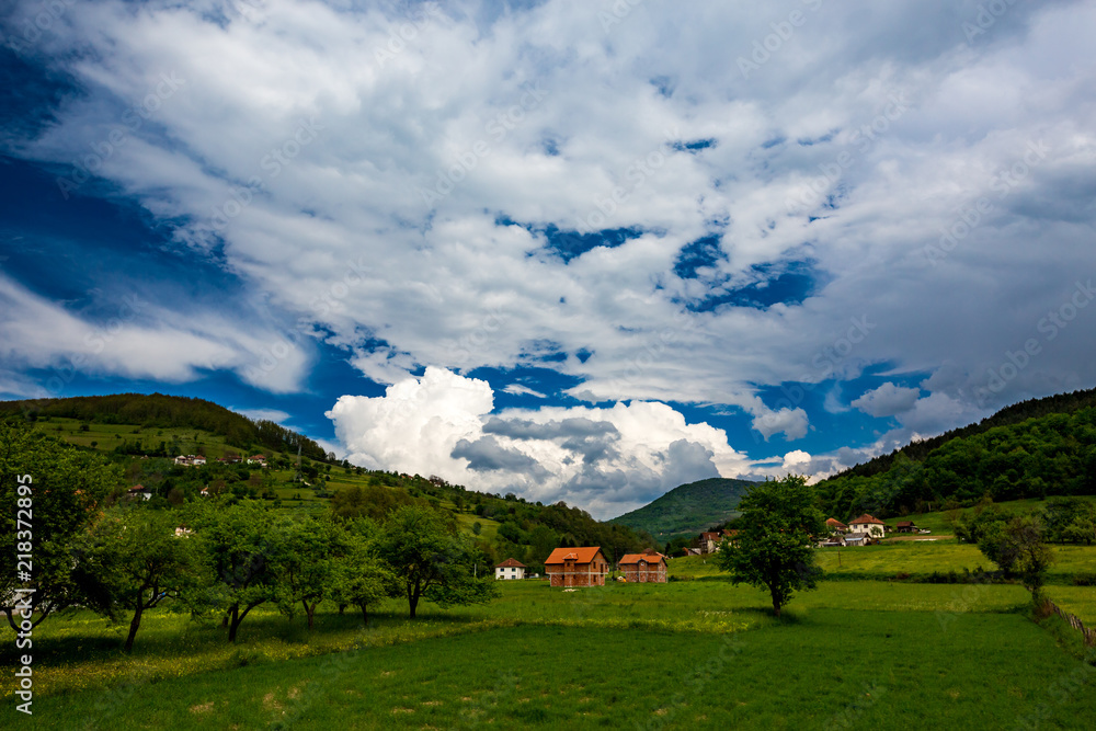 Serbian rural village green springtime landscape, mountains in Serbia are very beautiful, near Valjevo. Valley and hills. White and red houses, farmland and spring forest. Great European countryside