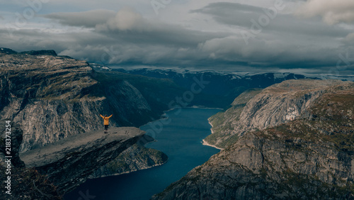 happy girl with wanderlust in norway at trolltunga