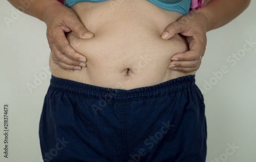 woman is worry body shape with for excess abdominal fat .