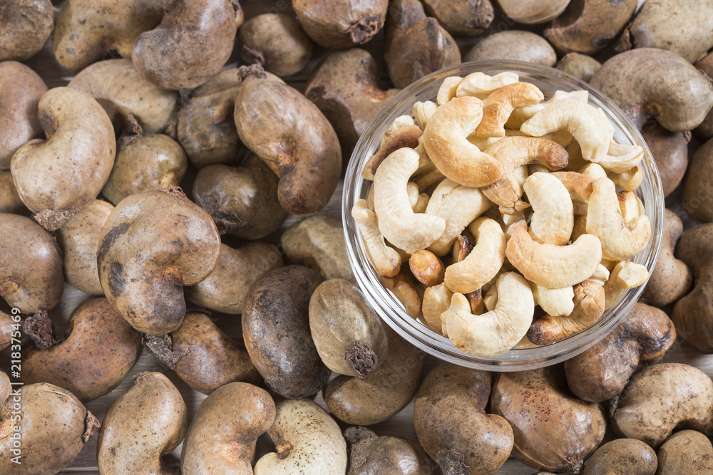 Natural and roasted cashew nut on wooden background - Anacardium occidentale Natural and roasted cashew nut on wooden background - Anacardium occidentale