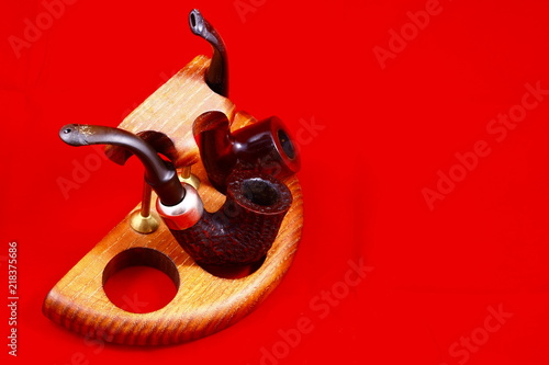 Smoking tubes, a violin and a mirror on a red background.