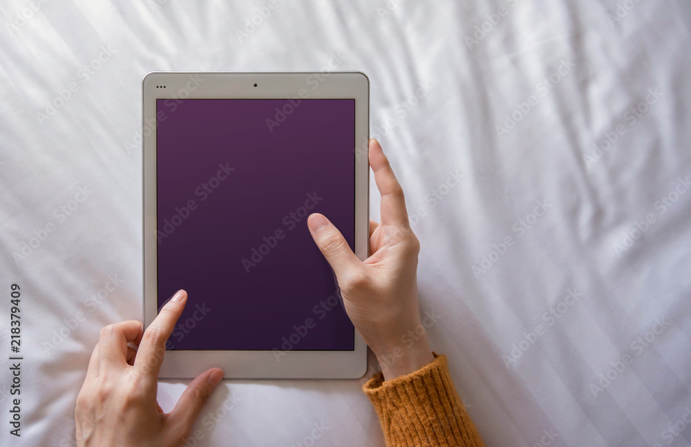 Mockup image of Digital Tablet. Woman Lay on Bed to using Tablet. Relaxing in the Morning. Top View, Screen as Clipping Path