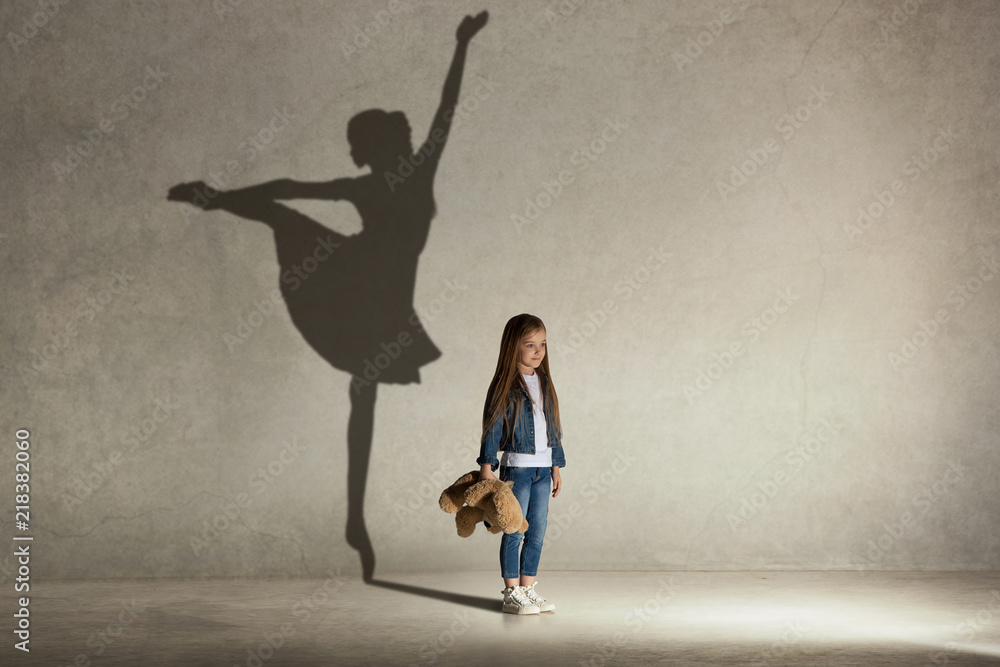 Baby girl dreaming about dancing ballet. Childhood and dream concept.  Conceptual image with shadow of ballerina on the studio wall Stock Photo |  Adobe Stock
