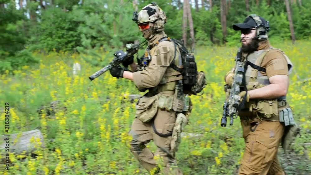 Close up airsoft men in ammunition go with machinegun. View from side Close up airsoft men in ammunition go with machinegun. View from side