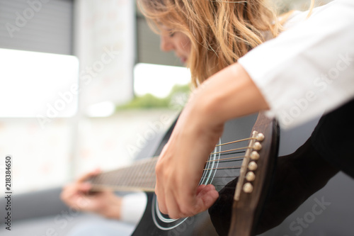 Woman plays her left-handed guitar at home after work in the office photo