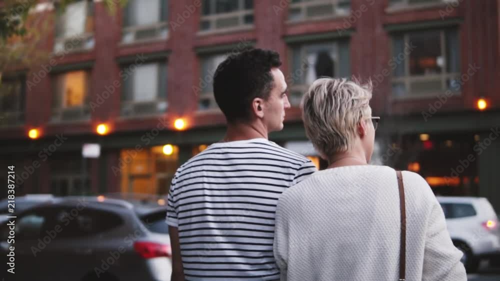 Slow motion happy young romantic couple talking while exploring beautiful streets of New York City, camera panning right Slow motion happy young romantic couple talking while exploring beautiful streets of New York City, camera panning right