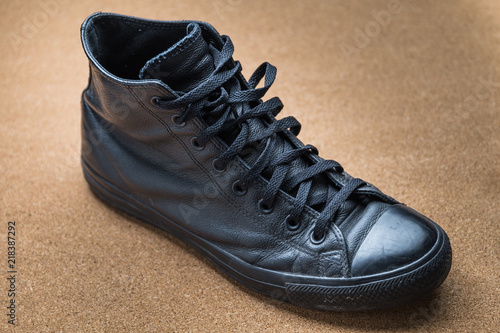 close up of a black leather sneaker on a craft material surface © Morocko