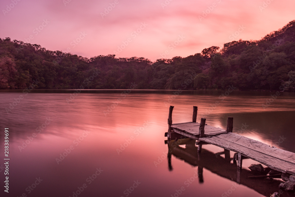 Beautiful pink sunset above a pier in a lagoon  