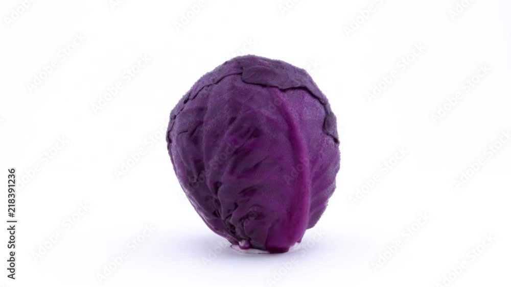 One whole mini purple cabbage is rotating on the turntable. Water drops appears on the skin during rotation. Isolated on the white background. Close-up. Macro. One whole mini purple cabbage is rotating on the turntable. Water drops appears on the skin during rotation. Isolated on the white background. Close-up. Macro.