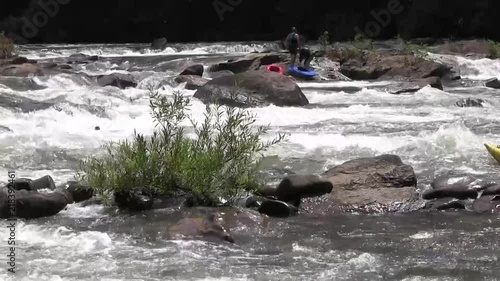 Kayakers pass by on a rushing river