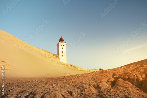 Beautiful sunset view of the lighthouse and sand desert dunes and ocean. Rubjerg Knude Lighthouse, Lønstrup in North Jutland in Denmark, Skagerrak, North Sea