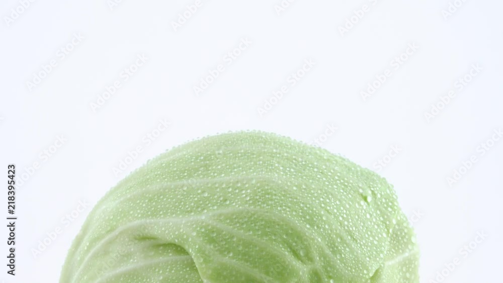 Macro shooting of upper part of one whole mini white cabbage with water drops. Slowly rotating on the turntable isolated on the white background. Close-up. Macro shooting of upper part of one whole mini white cabbage with water drops. Slowly rotating on the turntable isolated on the white background. Close-up.