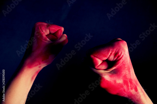 female fists in blood on black background