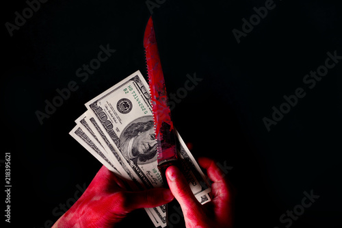 hungred dollar bills in blood on dark background photo