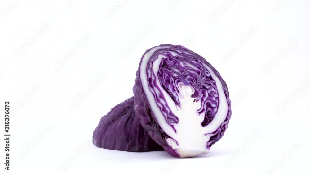 Two halves of mini purple cabbage with water drops. Cross cut. Rotating on the turntable isolated on the white background. Close-up. Macro. Two halves of mini purple cabbage with water drops. Cross cut. Rotating on the turntable isolated on the white background. Close-up. Macro.