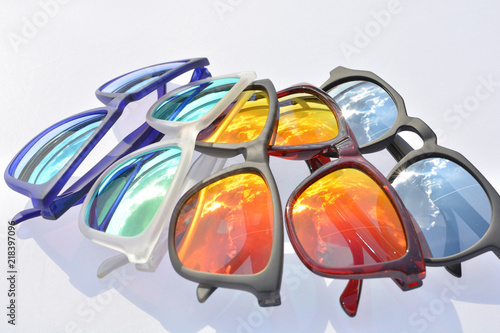 gafas de sol polarizadas con cristales  y monturas de diferentes colores usadas para proteger los ojos de los rayos uv durante el verano photo