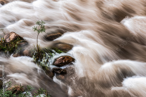 Motion stream of brown mud river from tropical rainforest in long exposure effect.