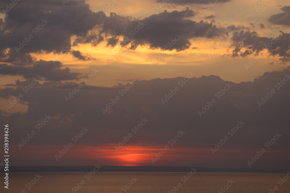Beautiful sunset with clouds of orange and yellow in the ocean, the river