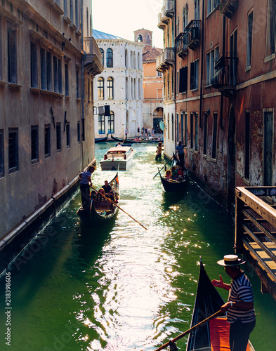 Gondola with passengers floats on small Venice canal. Canal Grande, Venice, Italy © JackStock