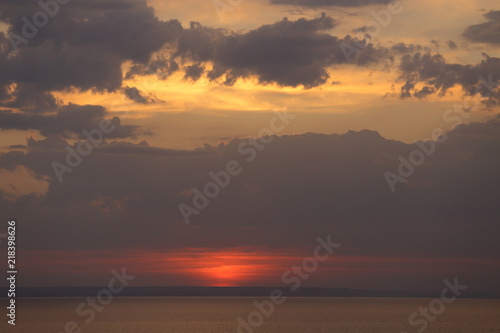 Beautiful sunset with clouds of orange and yellow in the ocean, the river