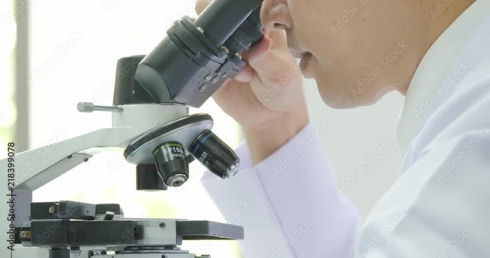 Medical research scientists in laboratory looking through a microscope. Medical research scientists in laboratory looking through a microscope.