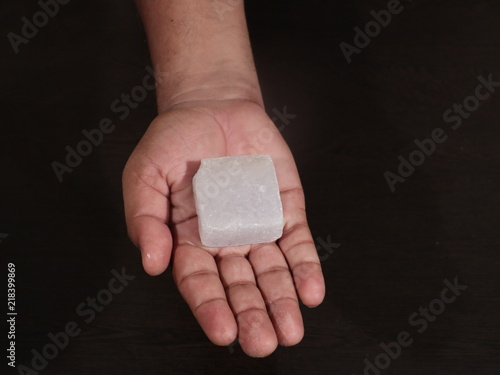 A lump of alum crystal. Alum is a most useful and effective remedy for various health problems such as skin problem, ulcers etc. Besides these, it’s used for water purification.Fitkari in Hand
