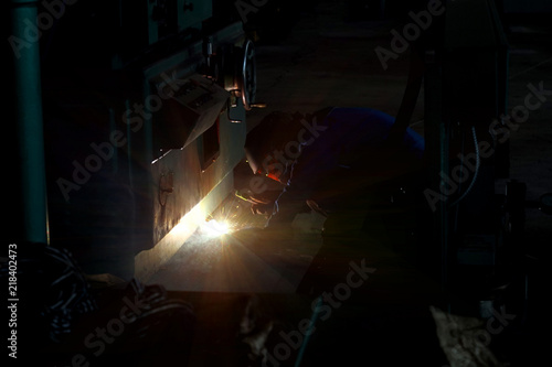 The welder at the industrial plant makes the connection using an electric arc.