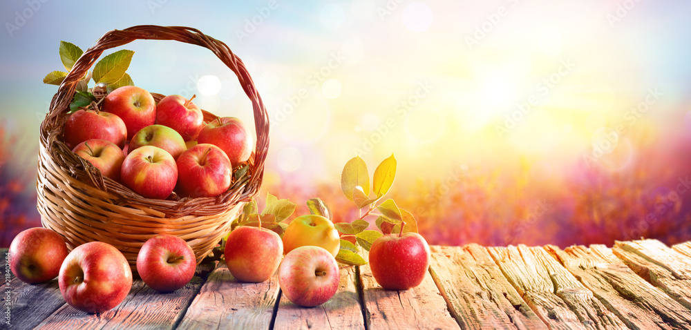 Red Apples In Basket On Aged Table At Sunset
 - obrazy, fototapety, plakaty 