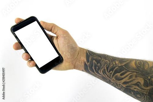 фотографія Studio shot with a hand holding a device with forearm tattooed