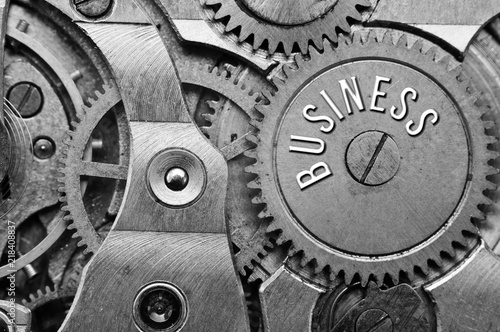 Background with the inscription BUSINESS. Black white background with metal cogwheels clockwork. Macro. 