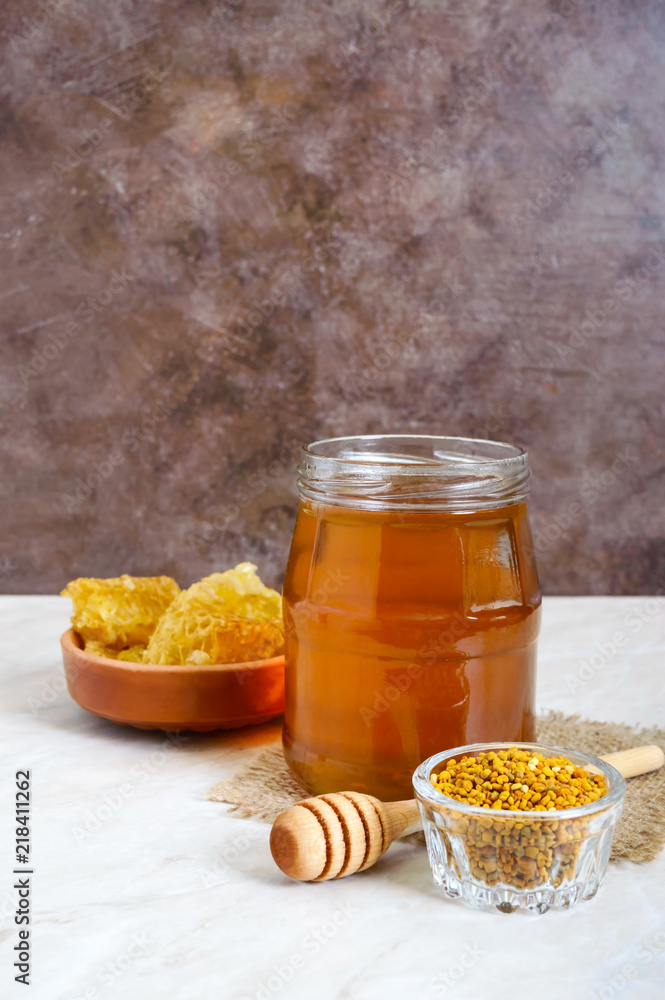 Honey in a glass jar, honeycomb, pollen. Products of beekeeping. The concept of healthy eating. Honey in a glass jar, honeycomb, pollen. Products of beekeeping. The concept of healthy eating.