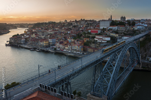 View of the beautiful city of Porto at sunset with the Douro River and the Dom Luis Bridge; Concept for visit Porto and travel in Portugal
