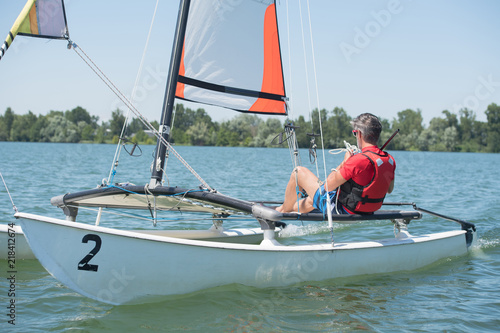 man sailing with sails out on a sunny day