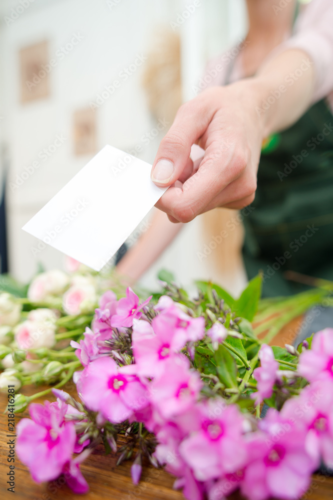 Obraz premium Florist holding card to accompany flowers