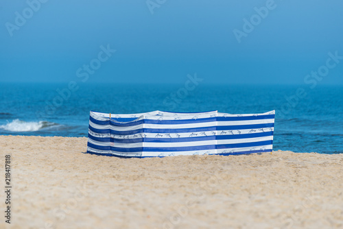 Beach screen on the Polish beach on a sunny summer day in the background beautiful sea.