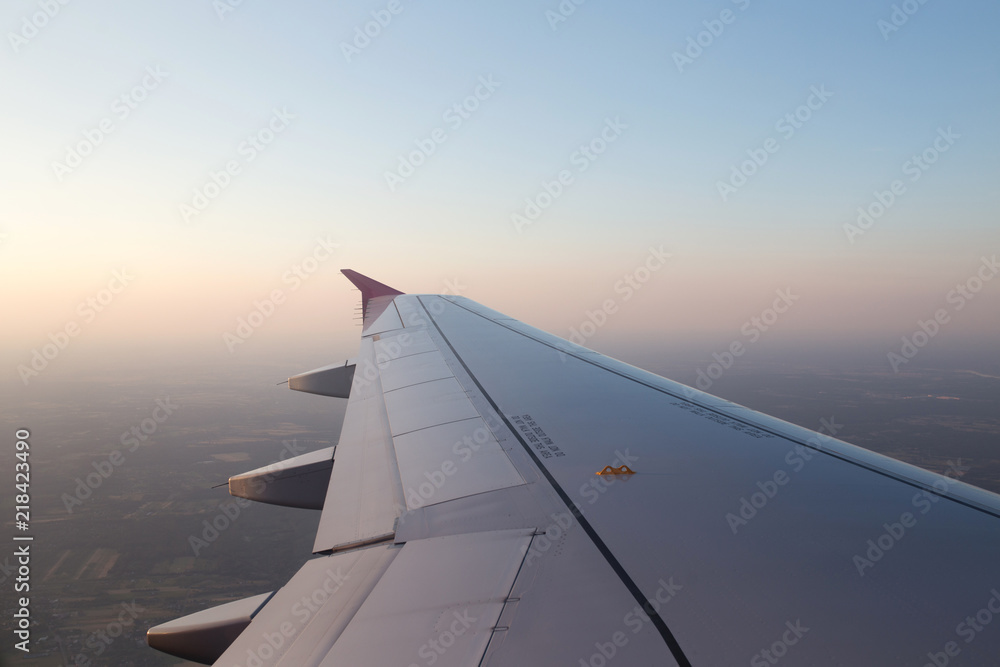 Flying above the clouds. Wing. Sunrise view from the airplane windoe. 