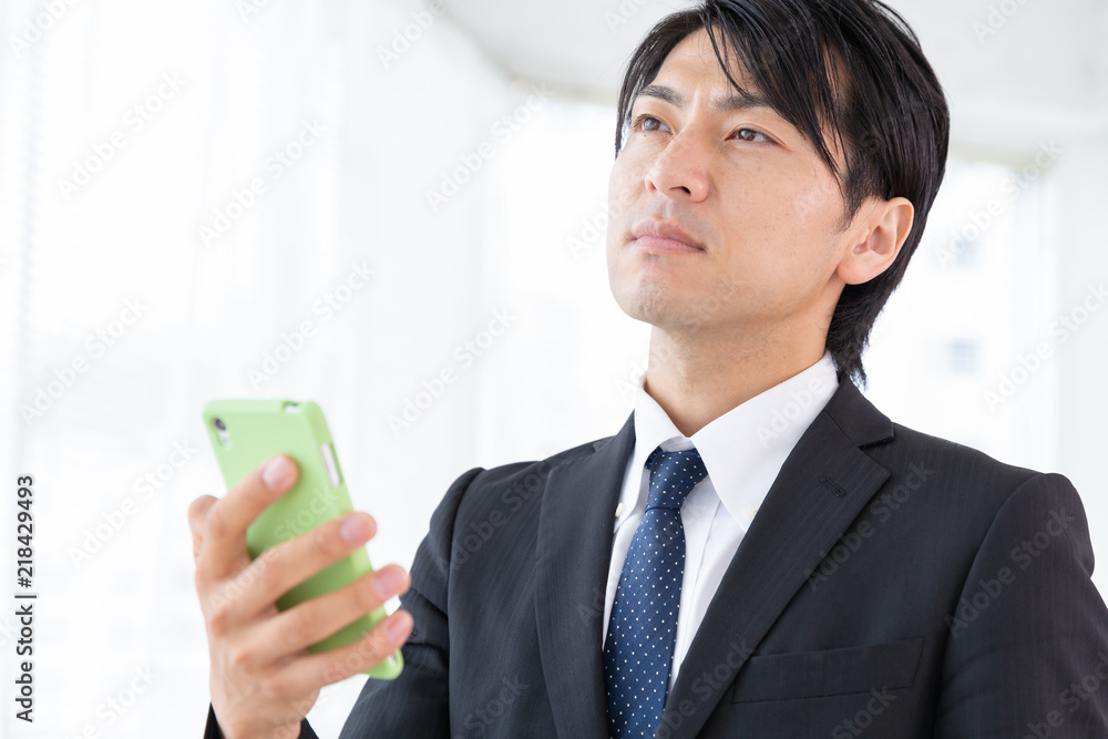 スマホを見るミドル男性　ビジネス