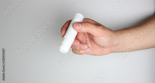 Glue stick in hand on a light background