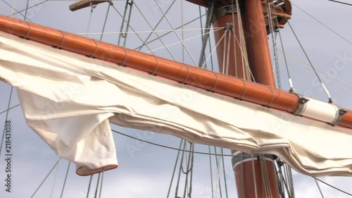 Rolled up the ship sails. Ropes and cords. Old wooden mast.  Panning,Closeup,  photo