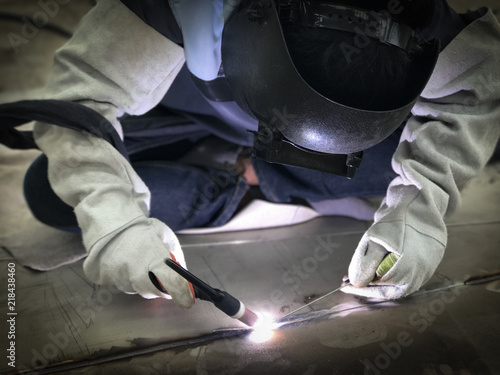 Worker welding stainless plate using tig welder
