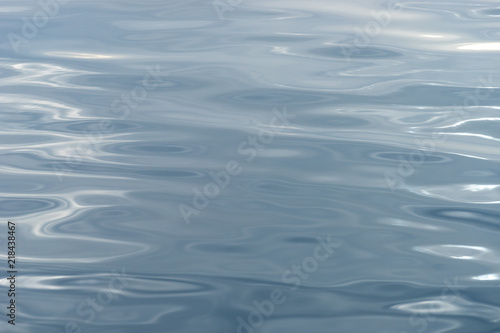 Sea water surface with reflection of the sun and small wave showing metallic color looks.