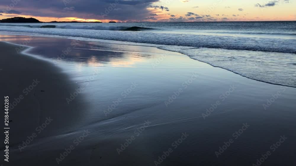 Waves and reflections on the beach before sunrise Waves and reflections on the beach before sunrise