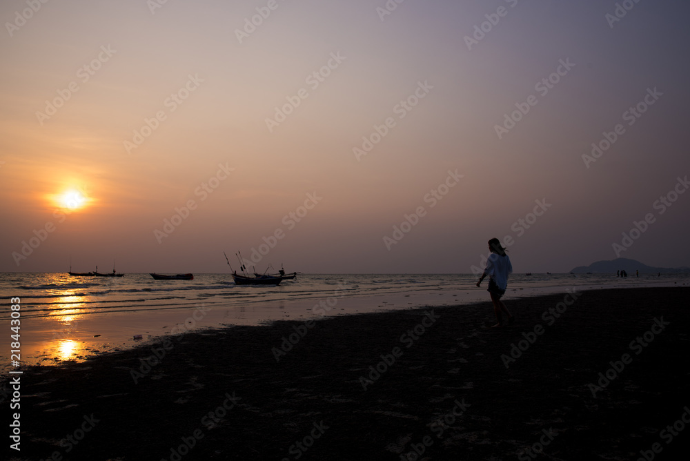 Silhouette of people on the beach at golden sunset time