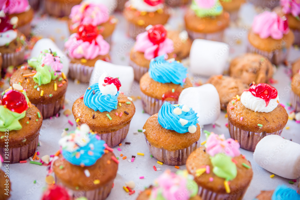 Many tasty colorful cupcakes on white background