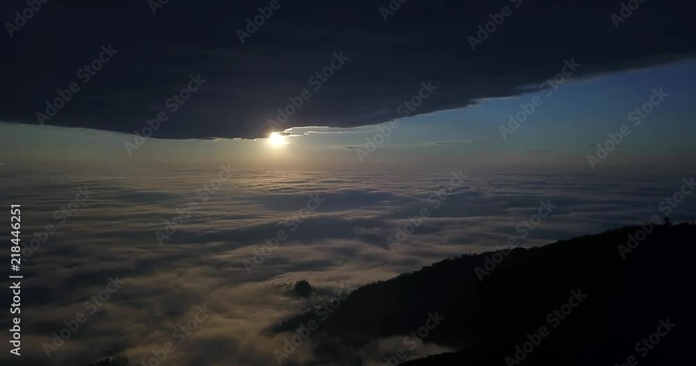 Flying over the clouds and mountains of Ecuador. A view of a sunset and part of the mountain in the background. Flying over the clouds and mountains of Ecuador. A view of a sunset and part of the mountain in the background.