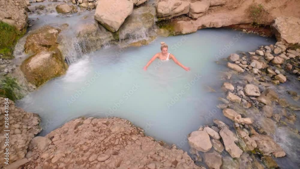Beautiful blonde girl in bikini having fun in a hot spring in slow motion Beautiful blonde girl in bikini having fun in a hot spring in slow motion